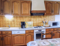 a kitchen with wooden cabinets and a microwave